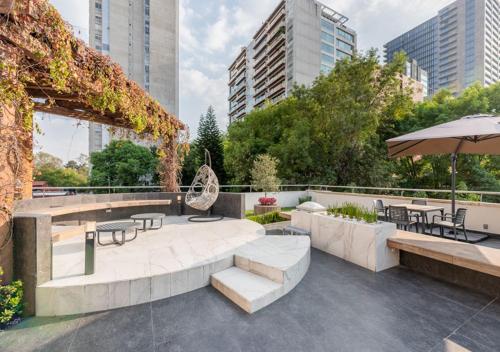 a patio with tables and chairs and an umbrella at Lamartine 619 Residencial in Mexico City
