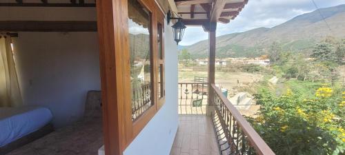 a room with a balcony with a view of the mountains at Hotel Villa Javier VDL in Villa de Leyva