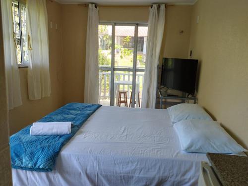 1 dormitorio con 1 cama, TV y ventana en Pousada Rota Do Beija Flor PACOTI-CE en Pacoti