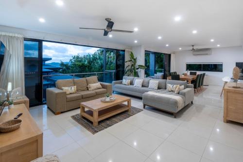 a living room with couches and chairs and a table at Pinnacle Apartments on Hamilton Island by HIHA in Hamilton Island