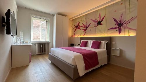 une chambre avec un lit avec un tableau sur le mur dans l'établissement SAN LORENZO Luxury Boutique, à Mantoue