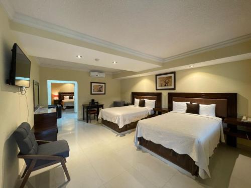 a hotel room with two beds and a television at Hotel San Ignacio Inn in Torreón