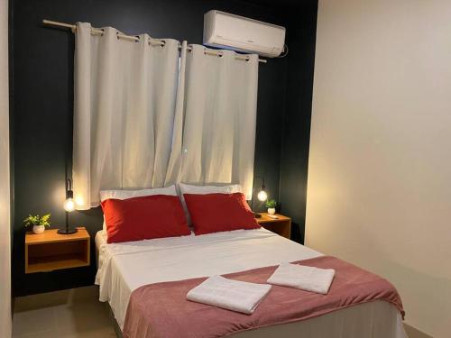 a bedroom with a large bed with red pillows at AP 102-B San Pietro - Térreo in Palmas