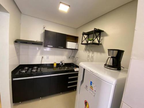 a kitchen with a stove and a refrigerator at AP 102-B San Pietro - Térreo in Palmas