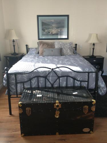 a bedroom with a bed with a trunk on it at Sweet Boutique Suite in Langley