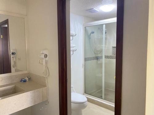 uma casa de banho com um chuveiro, um WC e um lavatório. em Hotel San Ignacio Inn em Torreón