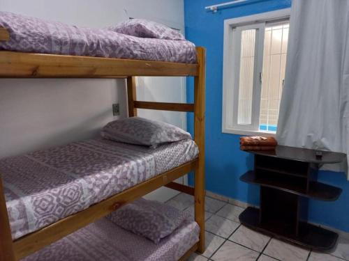 two bunk beds in a room with a window at Suíte Barros in Navegantes