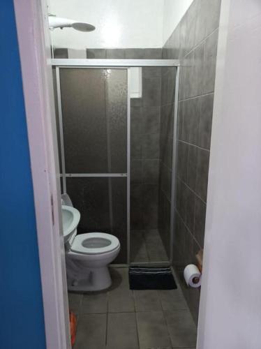 a small bathroom with a toilet and a shower at Suíte Barros in Navegantes