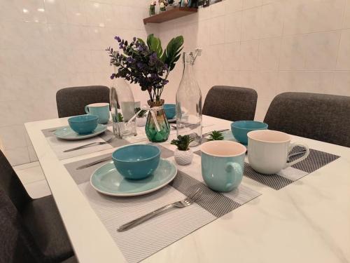 a table with blue bowls and plates on it at (WI-FI) Ipoh Holiday Big House double storey DR8 in Ipoh