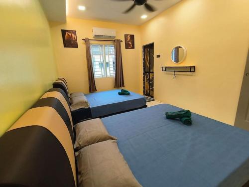 a room with four beds lined up in a row at (WI-FI) Ipoh Holiday Big House double storey DR8 in Ipoh