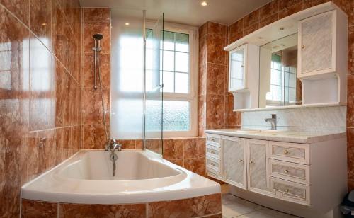 uma casa de banho com uma banheira, um chuveiro e um lavatório. em Résidence Hélios Paris Orly Aéroport em Villeneuve-Saint-Georges