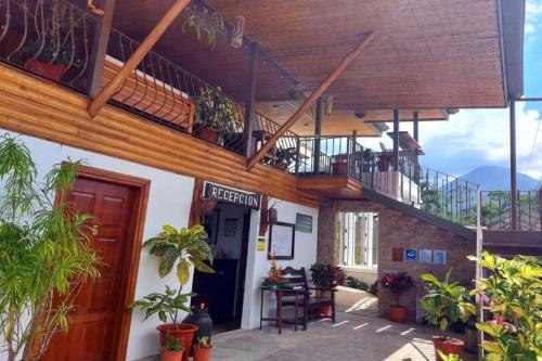 a house with a balcony and a staircase at La Fortuna Lodge by Treebu Hotels in Fortuna