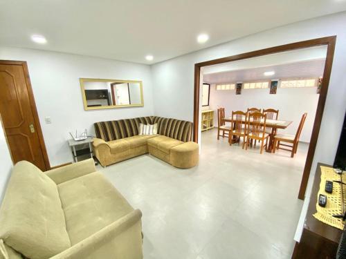- un salon avec un canapé et une salle à manger dans l'établissement Apto a 20 metros da praia, à Capão da Canoa