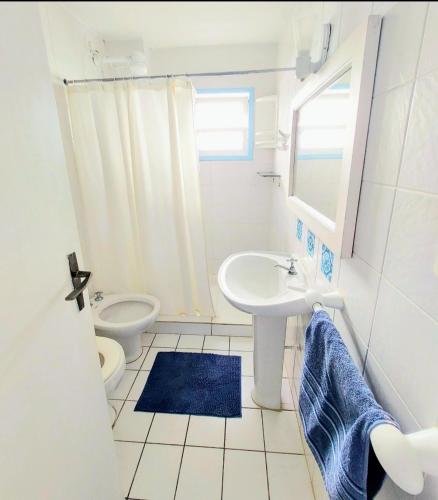 a white bathroom with a sink and a toilet at Pousada Los Casarones in Florianópolis