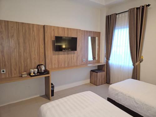 Postel nebo postele na pokoji v ubytování The Safiina Point Syariah Hotel