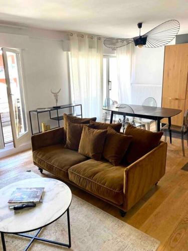 un salon avec un canapé marron et une table dans l'établissement LA PERLE DU THIOU - Charmant T3 au Centre d'Annecy avec Parking Privé, à Annecy