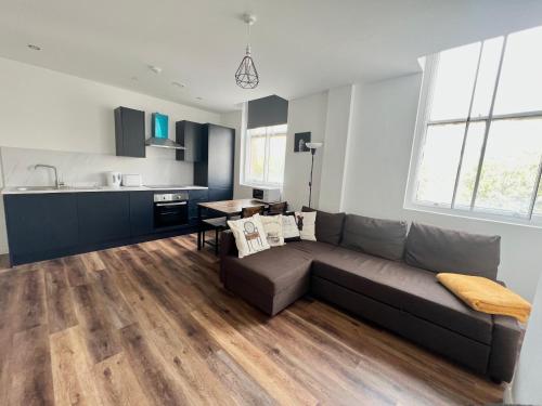 a living room with a couch and a kitchen at Apartment - City Centre WV1 in Wolverhampton