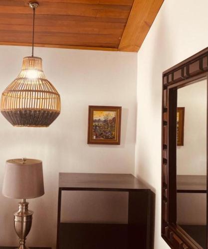 a room with a mirror and a table and a lamp at La Fortuna Lodge by Treebu Hotels in Fortuna