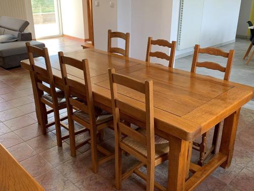 - une table à manger en bois avec des chaises en bois dans l'établissement Maison de charme rénovée proche Verdun, idéal randos, 3 ch, jardin, terrasse, cuisine équipée - FR-1-585-48, à Forges-sur-Meuse