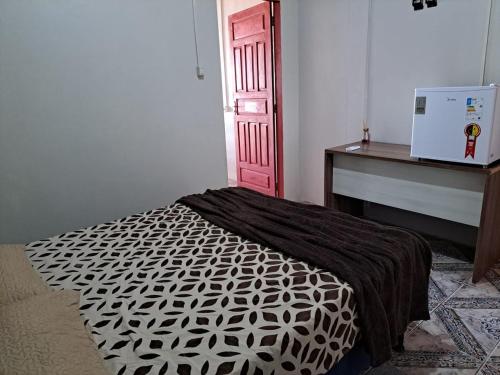 um quarto com uma cama e uma porta vermelha em AP 2 - Apartamento Mobiliado Tamanho Família - Cozinha Completa em Macapá