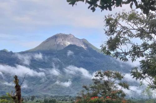 Une montagne au loin avec des nuages devant elle dans l'établissement Mt Apo View Creekside Whole house with Pool by Creek Cowboys Cottage, à Digos