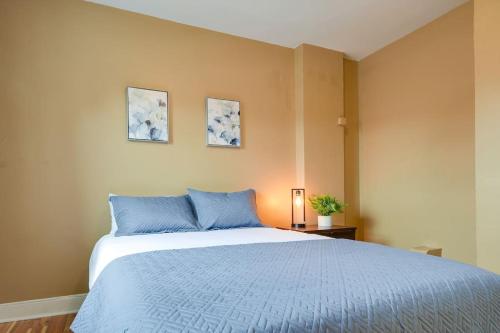 a bedroom with a large bed with blue pillows at Cozy Retreat in Downtown Lancaster with Backyard Patio in Lancaster