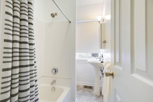 a white bathroom with a tub and a sink at Cozy Retreat in Downtown Lancaster with Backyard Patio in Lancaster