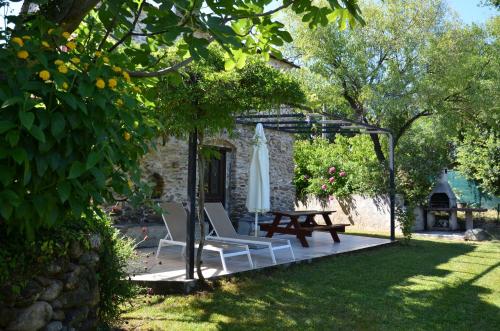 a patio with a table and chairs and an umbrella at Residence de tourisme Le clos des Vendanges in Moriani Plage