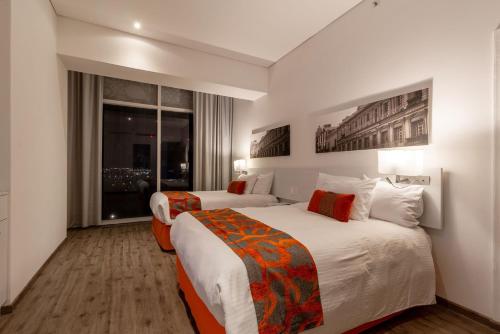 a hotel room with two beds and a window at Camino Real Puebla Angelopolis in Puebla