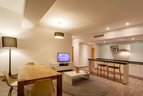 a living room with a table and a dining room at Camino Real Puebla Angelopolis in Puebla