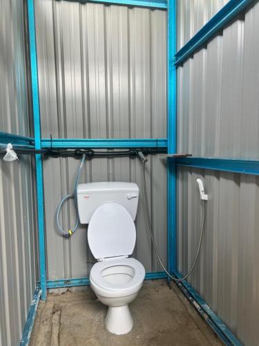 a bathroom with a toilet in a metal stall at Redang Campstay in Redang Island