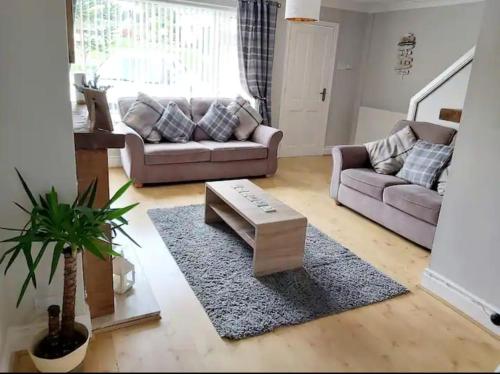 a living room with a couch and a coffee table at Croeso; Cosy and ideally located for mountains and beaches in Deganwy
