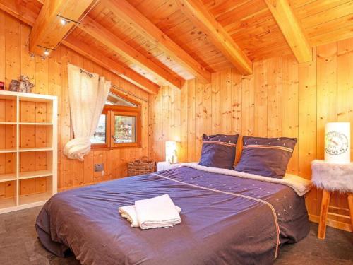 een slaapkamer met een bed in een houten hut bij Chalet in Moulin with Sauna & Stunning Views in Peisey-Nancroix