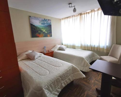 una habitación de hotel con 2 camas y una silla en Bon Repos Arequipa, en Arequipa