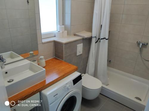 ein Badezimmer mit einem Waschbecken und einer Waschmaschine in der Unterkunft Apartments by the sea Kuciste - Perna, Peljesac - 4544 in Kučište