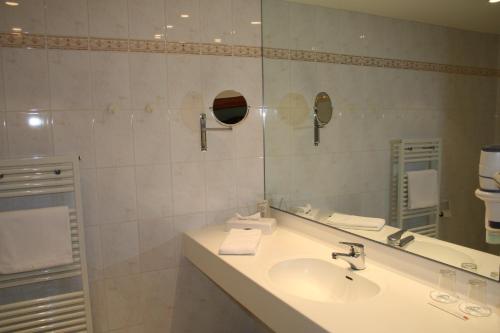 a bathroom with a sink and a mirror at Rheinhotel Larus in Kaltenengers