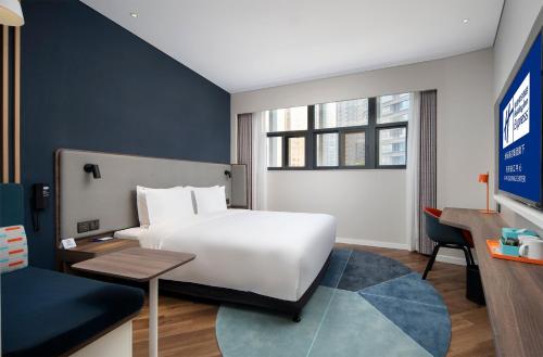 ein Hotelzimmer mit einem Bett und einem Schreibtisch in der Unterkunft Holiday Inn Express Xi'an Qujiang Center, an IHG Hotel in Xi'an