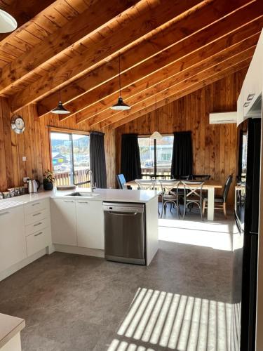 a kitchen with white cabinets and a dining room with a table at Alpine Motel in Ohakune