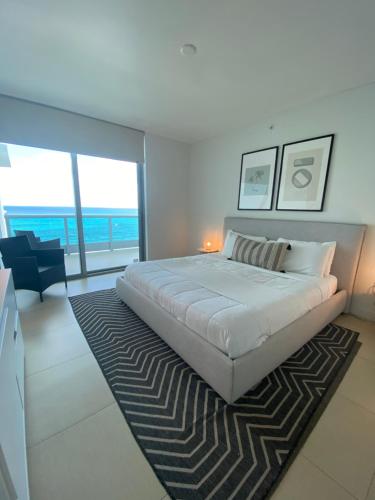 a white bedroom with a large bed and a living room at Monte Carlo Suites in Miami Beach in Miami Beach