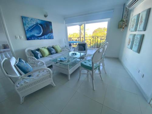 sala de estar con sofá, mesa y sillas en Apartamentos Classy Reef alado de la playa en San Andrés