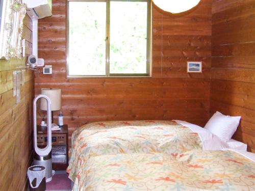 1 dormitorio con 1 cama en una habitación con ventana en Minamitsuru-gun - Hotel / Vacation STAY 45545 en Yamanakako