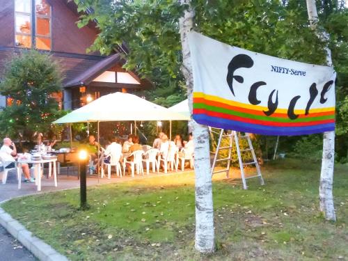a sign in the grass with people sitting at tables at Minamitsuru-gun - Hotel / Vacation STAY 45545 in Yamanakako