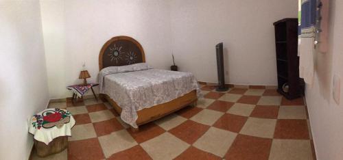 a bedroom with a bed and a checkered floor at Alojamiento en una tranquila casa rural 