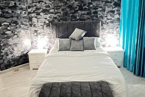 1 dormitorio con 1 cama blanca grande y cortinas azules en Linda casa en playa de Pozos Colorados, en Santa Marta