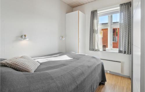 a white bedroom with a bed and a window at Stunning Apartment In Gudhjem With Wifi in Gudhjem