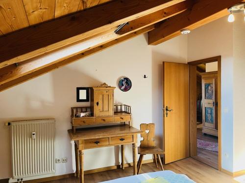 an attic room with a wooden desk and a chair at Haus Oberland in Bad Endorf