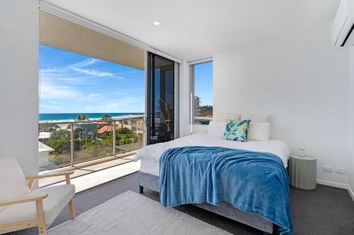 a bedroom with a bed and a large window at Wave Watcher's Delight at Acqua Palm Beach in Gold Coast