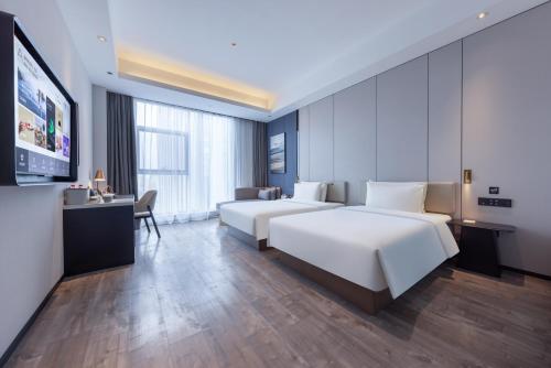 a hotel room with two beds and a desk at Atour X Hotel Shanghai Shuguang Wusong Cruise Terminal in Hujiazhai