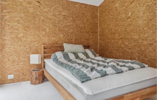een slaapkamer met een bed met een houten hoofdeinde bij Pet Friendly Home In Faxe Ladeplads With Wifi in Fakse Ladeplads