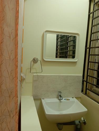 a bathroom with a sink and a mirror at Arangan kudil in Srīrangam